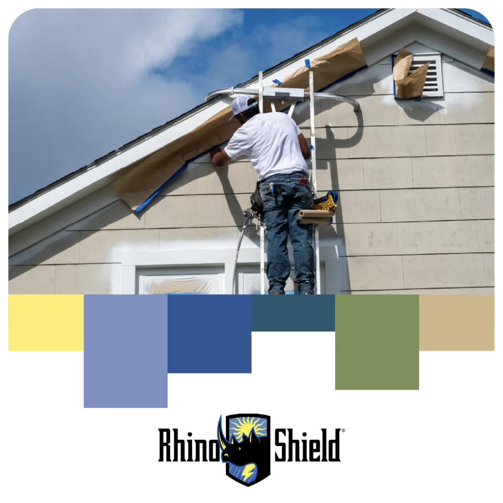 Painter on a ladder prepping a house exterior with Rhino Shield branding and color palette blocks below